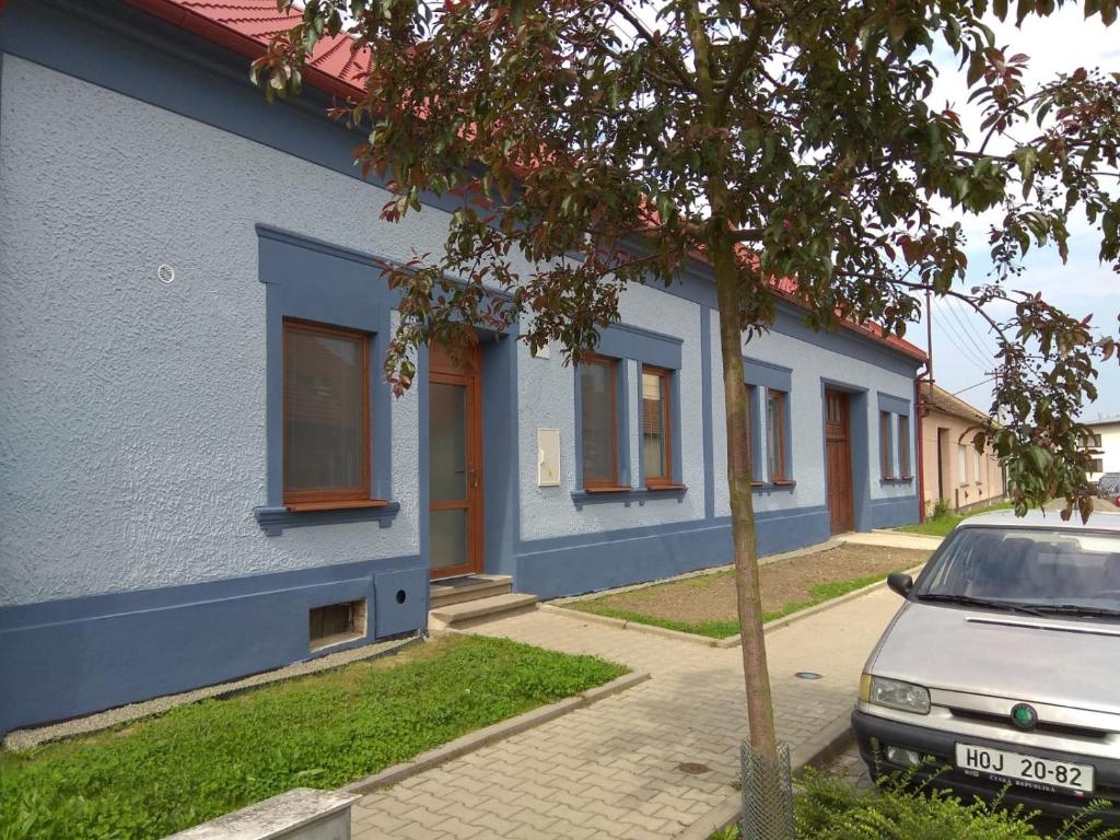 een blauw gebouw met een auto ervoor geparkeerd bij Apartmány U splavu in Veselí nad Moravou
