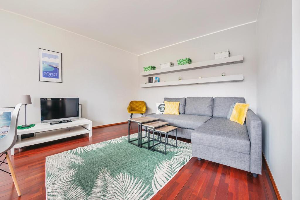 a living room with a couch and a tv at Apartamenty Sun&Snow Marina Primore in Gdańsk