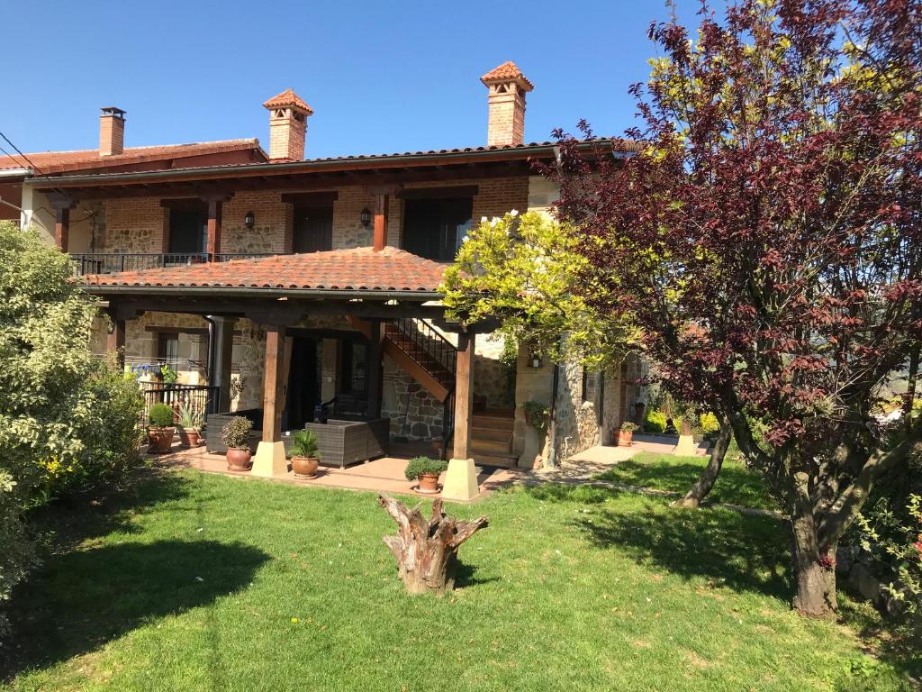 una casa con un árbol en el patio en Vitori's House Tourist Accommodation, en Ahedo