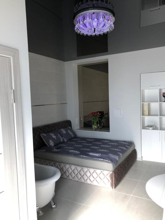 a bedroom with a bed and a chandelier at Romeo VIP apartamentai in Panevėžys