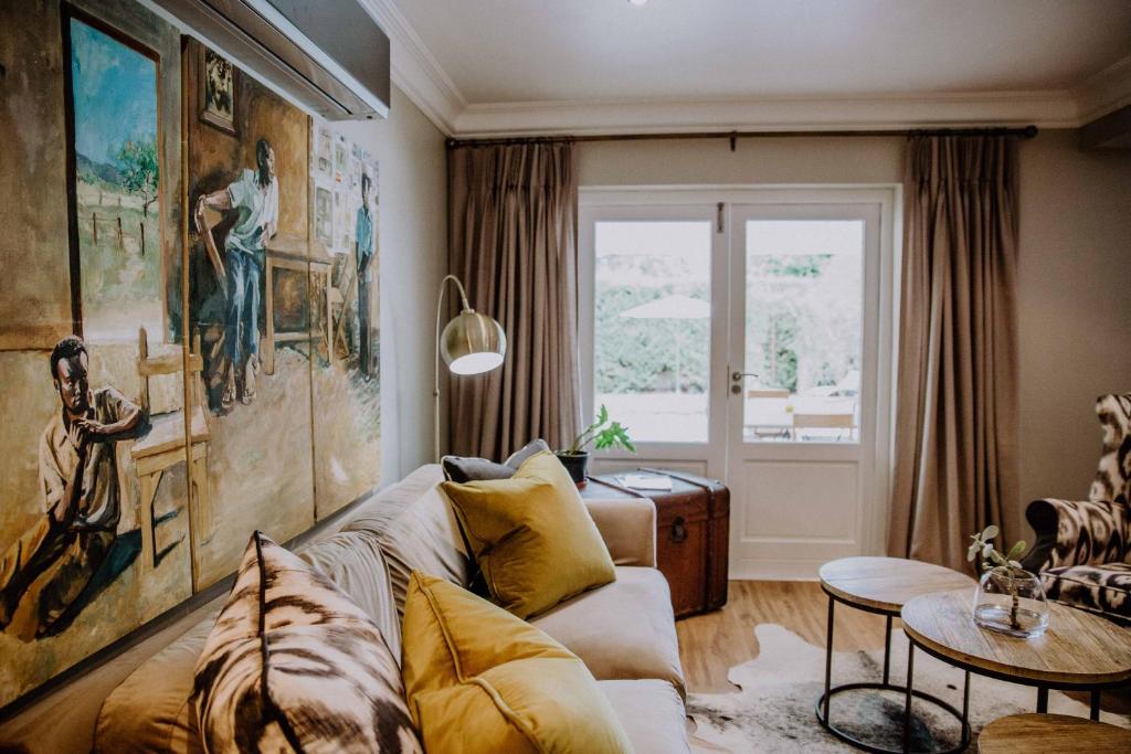 a living room with a couch and a table at Franschhoek Village House in Franschhoek