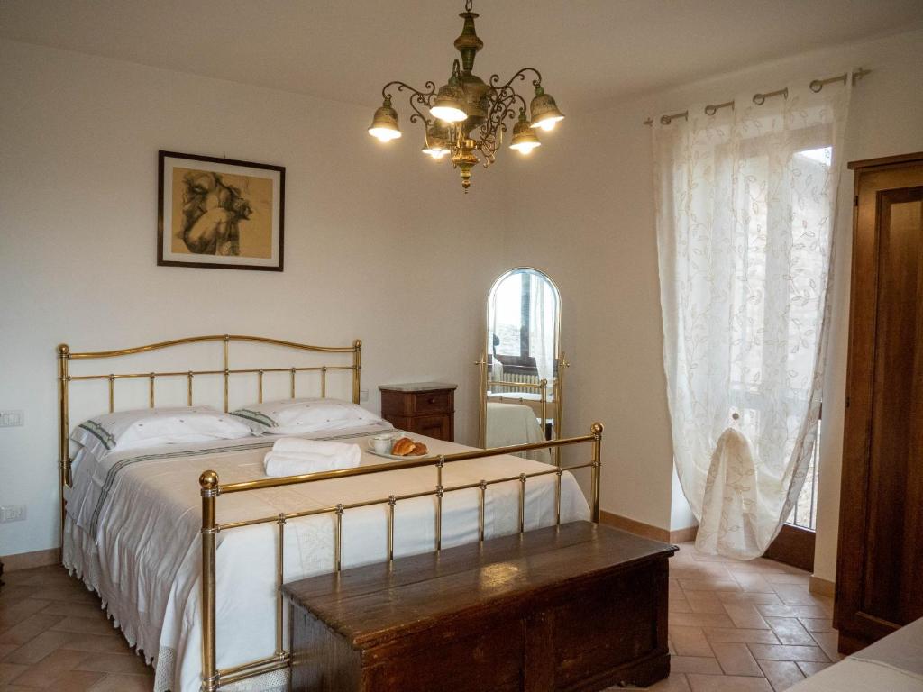 Un dormitorio con una cama y una lámpara de araña. en Domus Flora Guest House, en Spello