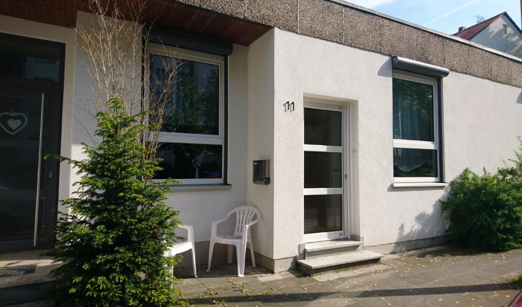 a white house with a white chair and a window at Doppel-Appartement Salzbrunner Str. 11, Langwasser Mitte in Nuremberg