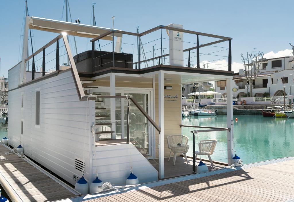 ein Haus am Wasser neben einem Yachthafen in der Unterkunft Portoverde Luxury Houseboat in Misano Adriatico