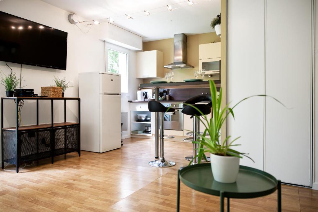 サン・グレゴワールにあるChic Appartement avec Terrasse, Parking Privatifのキッチン(冷蔵庫、テーブル付)
