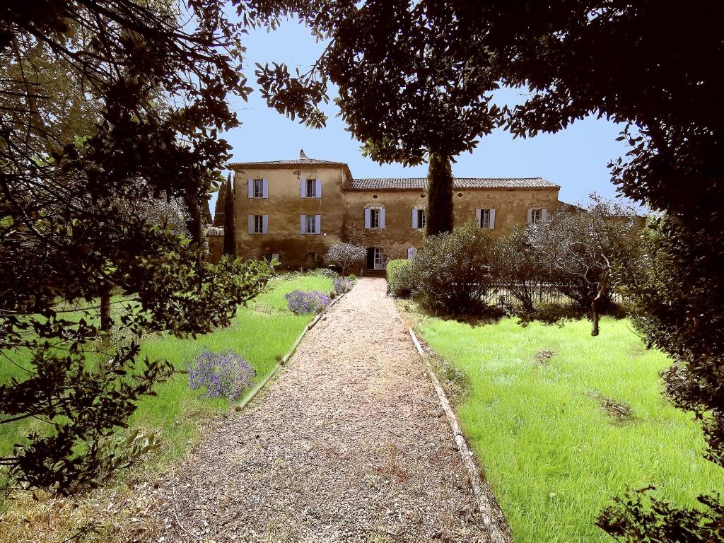 an old house with a garden in front of it at La Bastide du Farfadet in Laudun
