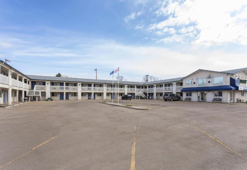 un aparcamiento vacío frente a un gran edificio en Motel Bo-Camrose, AB, en Camrose