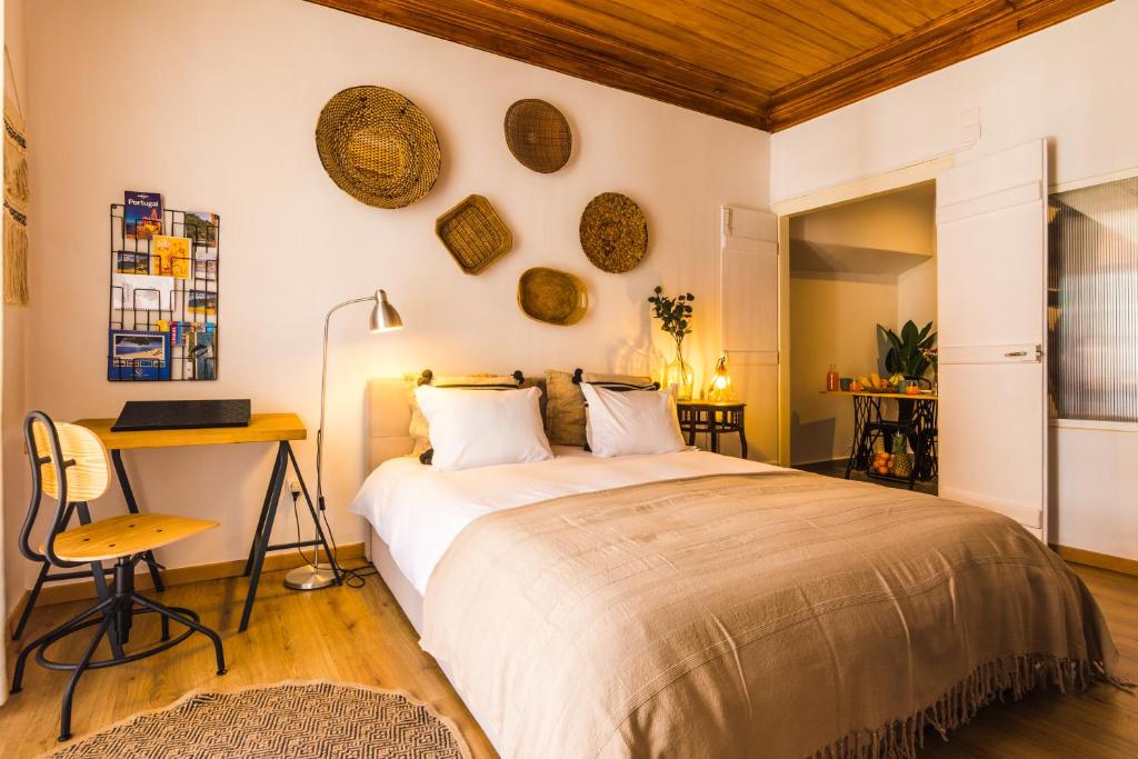 a bedroom with a large bed and a desk at Camões Lofty Boho Apartment in Setúbal