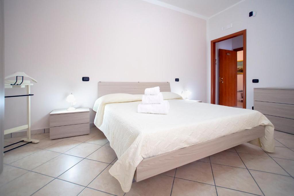 a white bedroom with a large bed with two towels on it at B&B NONNO MICHELE in Fisciano