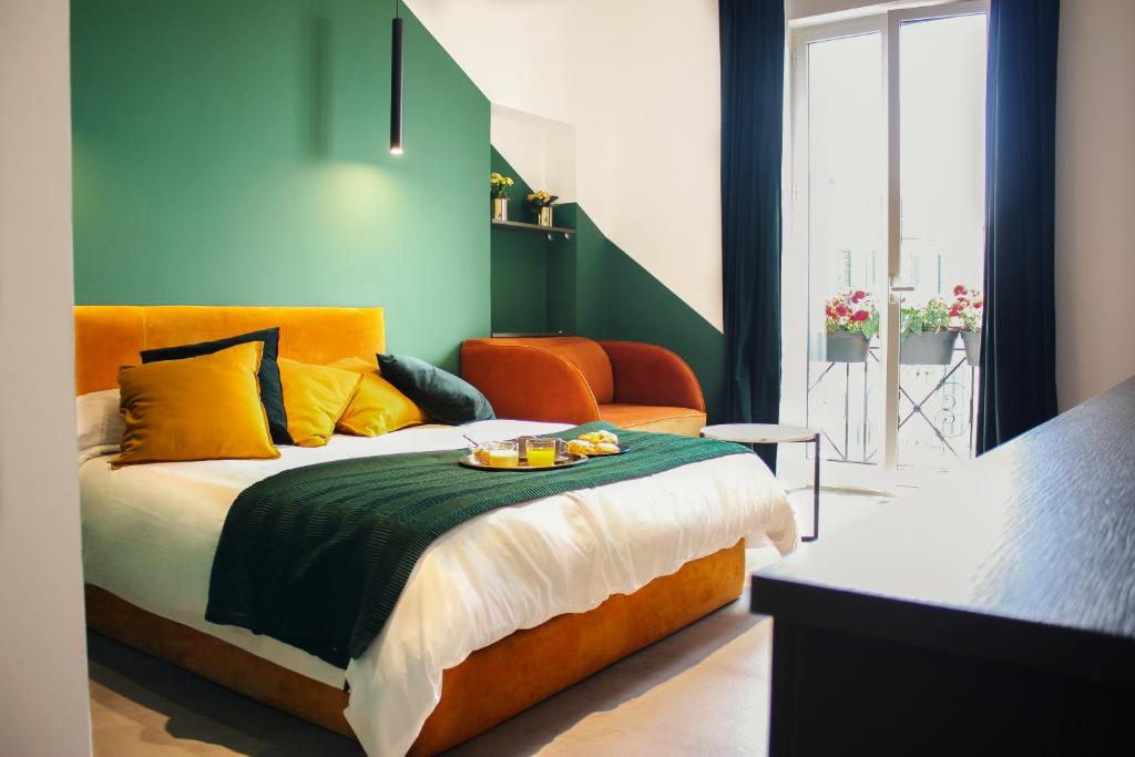 a bedroom with a bed with orange and green walls at Nacu 90 in Naples
