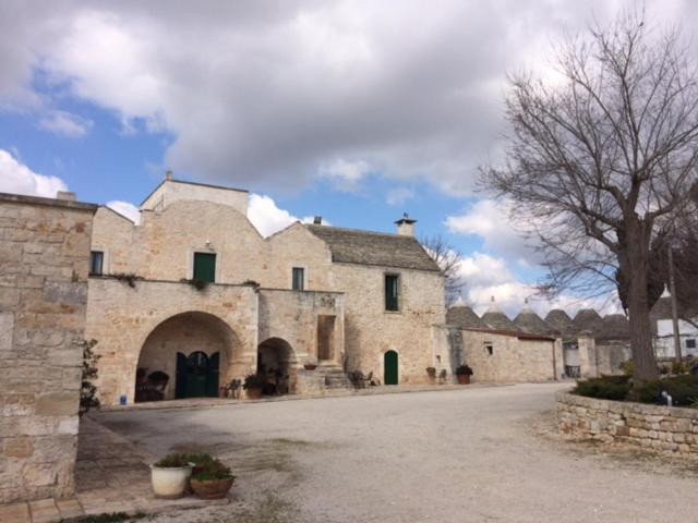 ein großes Steingebäude mit einem Baum davor in der Unterkunft Masseria Sant'Elia in Martina Franca