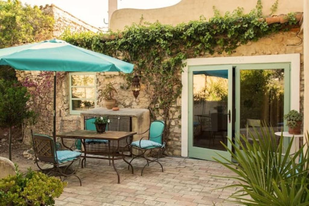 une terrasse avec une table, des chaises et un parasol dans l'établissement Casa La Premsa at Masia Nur Sitges, Adults only, à Canyelles