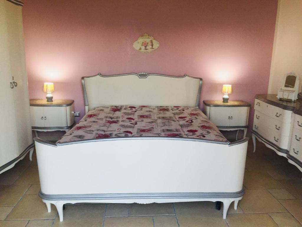 a bedroom with a bed with two dressers and two lamps at La Bella di Lamezia (Appartamento) in Lamezia Terme