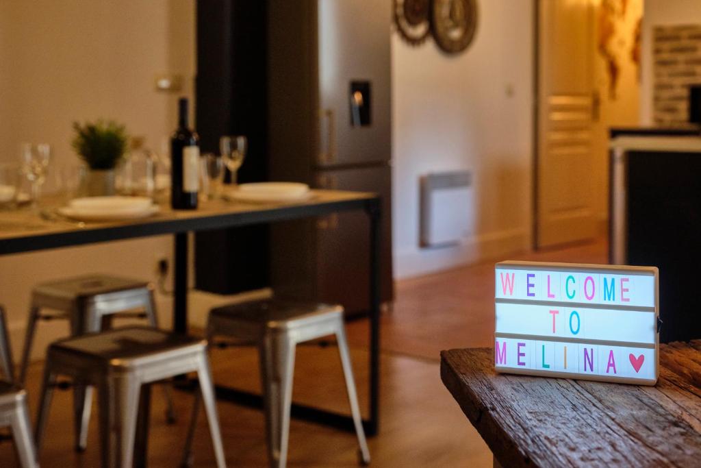 een teken dat zegt dat we naar de mensheid komen zittend op een tafel bij Mélina - appartement dans les remparts de la Bastide avec parking et terrasse in Carcassonne