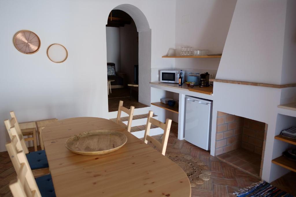 una cucina con tavolo e sedie in legno in una stanza di Casas de Mértola 29 a Mértola