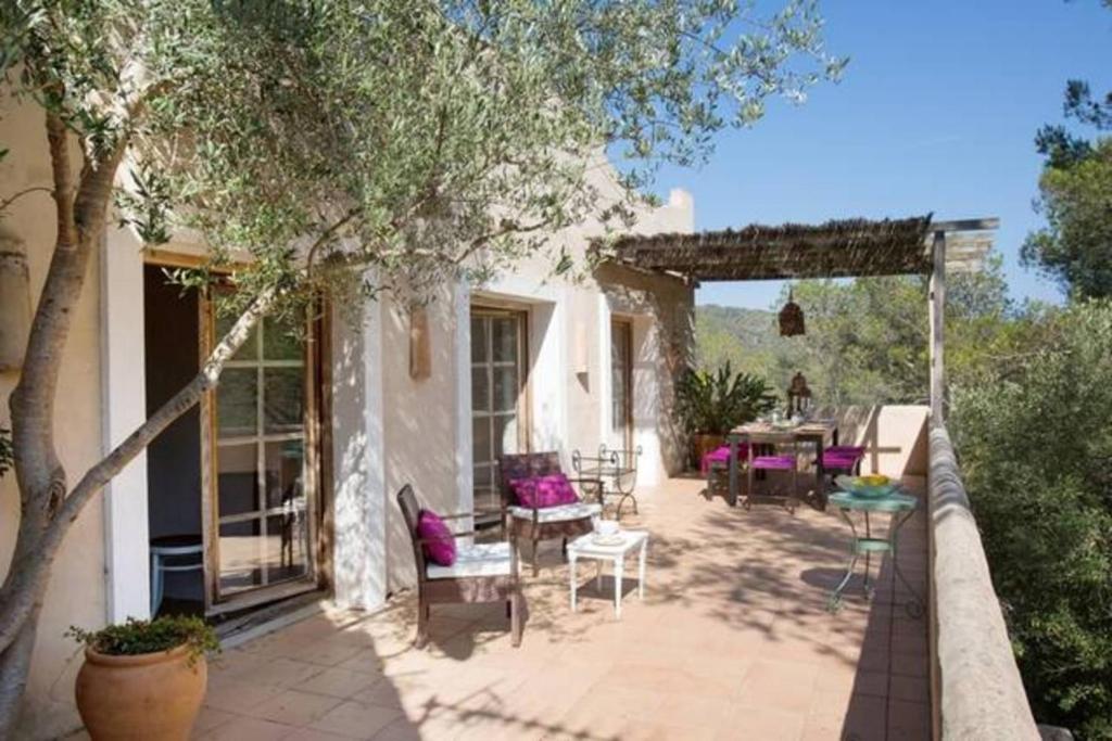 un patio con mesa y sillas en Villa Hermosa at Masia Nur Sitges, Adults only, en Canyelles