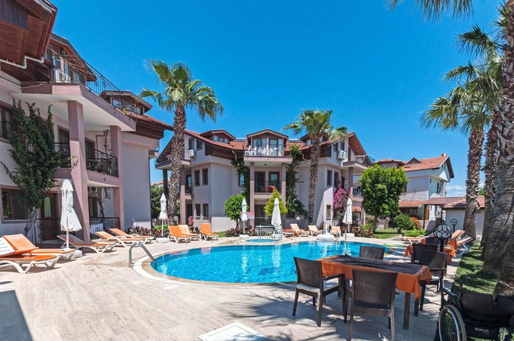 a villa with a swimming pool and palm trees at Minta Apartments in Dalyan