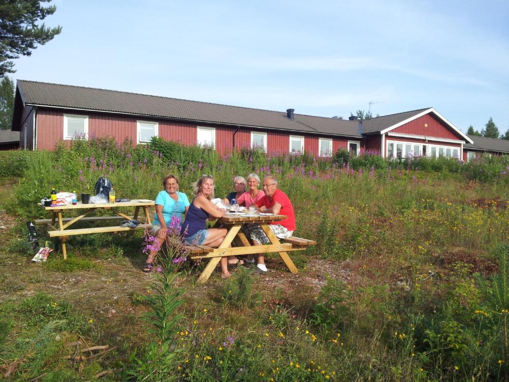 a group of people sitting at a picnic table at STF Orsa Hostel in Orsa