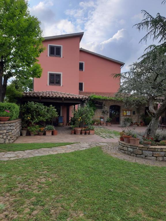a large pink building with a courtyard at Locanda al Giglio d'Oro in Ruvo del Monte