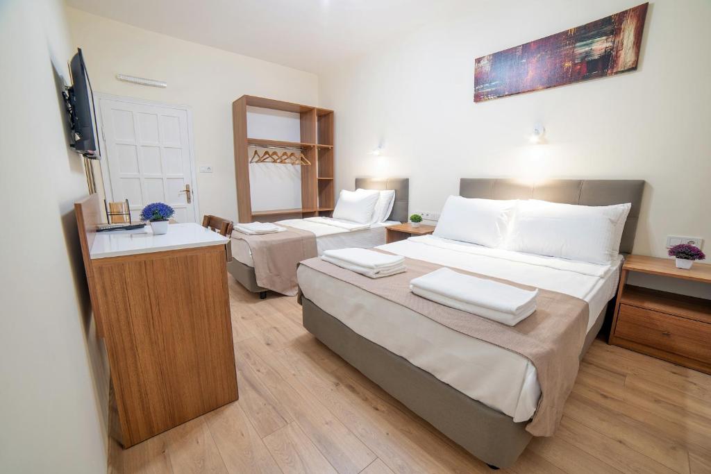 ein Hotelzimmer mit 2 Betten und einem TV in der Unterkunft 9Bodrum Hotel in Turgutreis
