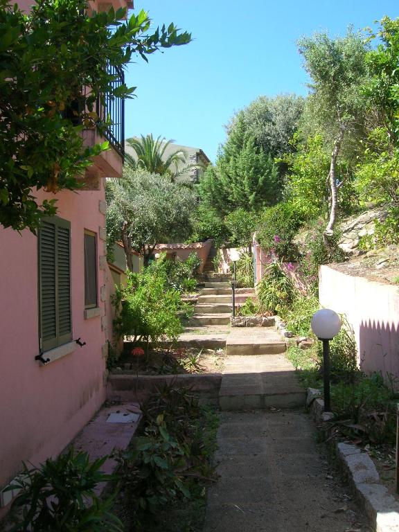 a walkway between two buildings in a garden at Villaggio Sa Ventana in Badesi