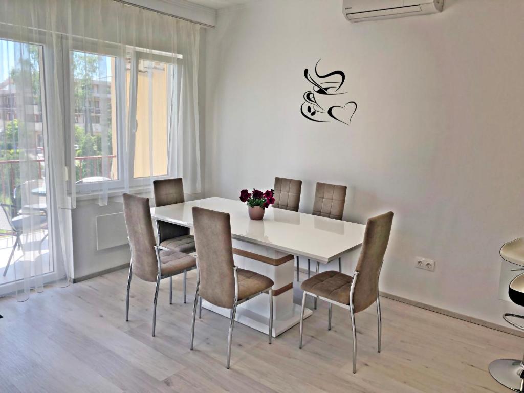 een eetkamer met een witte tafel en stoelen bij Szende Apartman in Balatonfüred