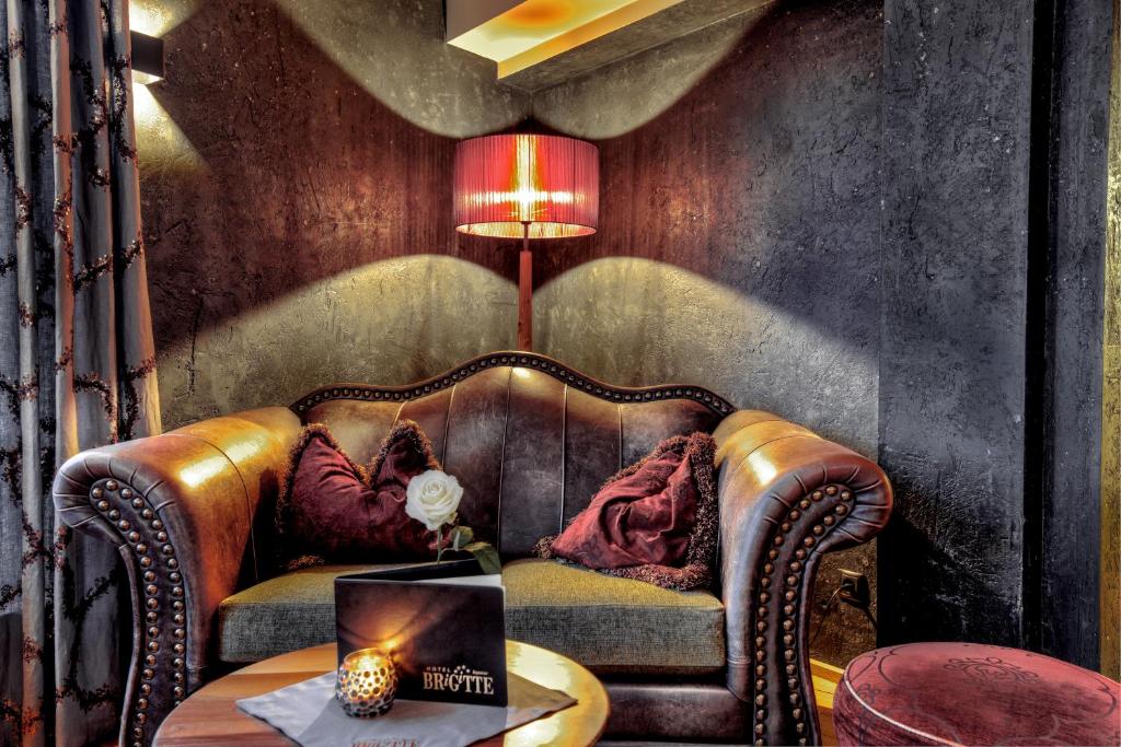 a living room with a leather couch and a table at Hotel Brigitte in Ischgl