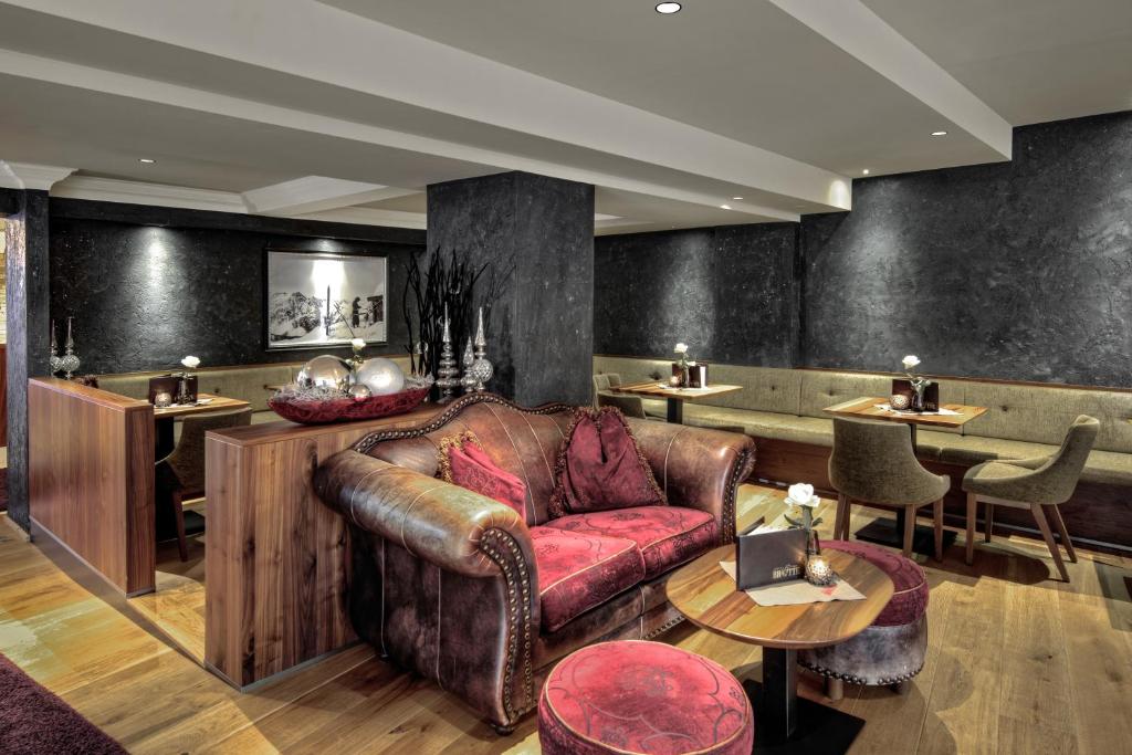 a living room with a leather couch and tables at Hotel Brigitte in Ischgl