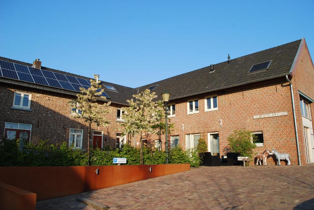 een groot bakstenen gebouw met zonnepanelen erop bij Hof Kricheleberg in Bocholtz