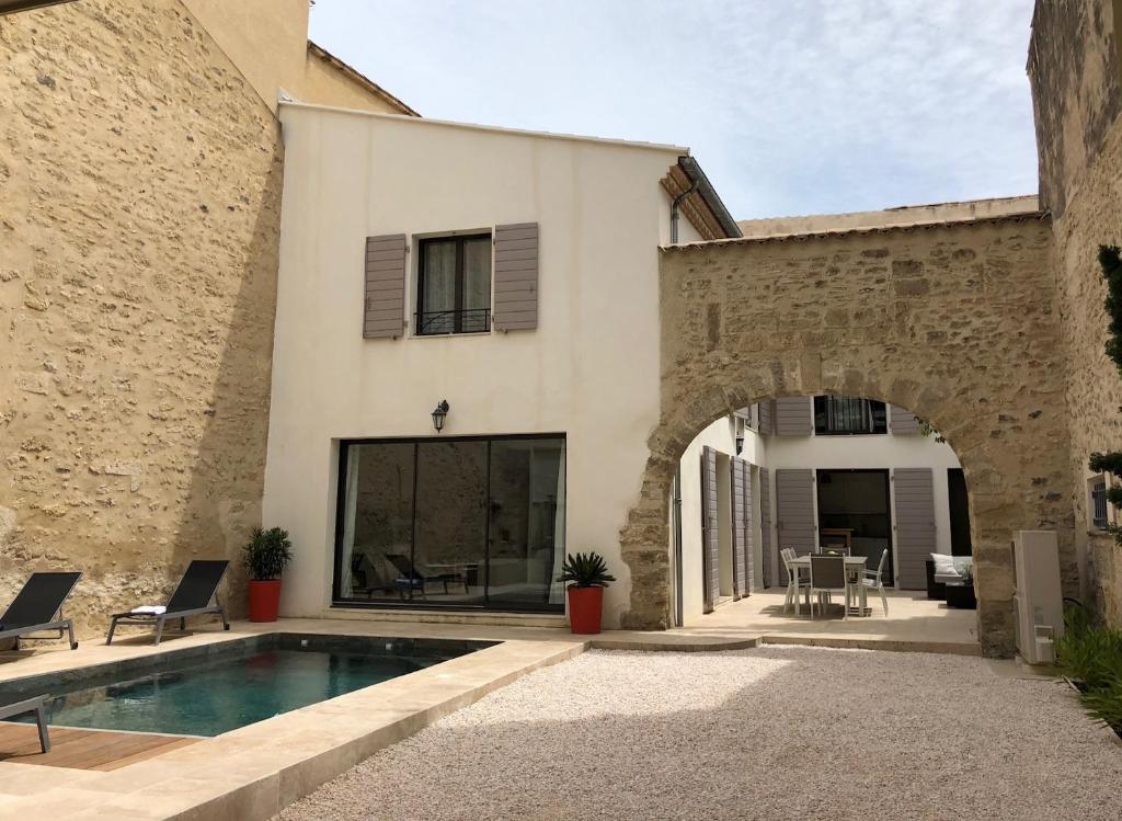 a house with a swimming pool in front of a building at ARCHE DE PEZENAS in Pézenas