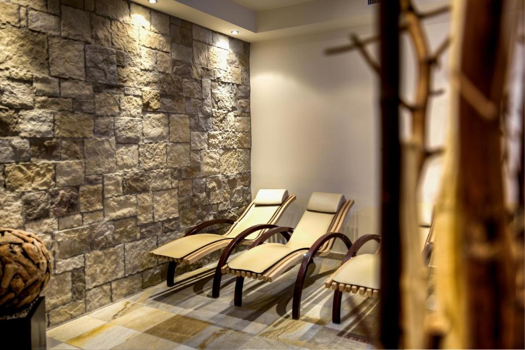 a row of chairs in a room with a stone wall at Hotel Brigitte in Ischgl