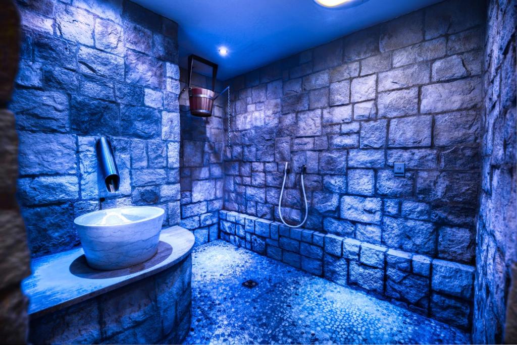 a stone bathroom with a sink and a shower at Hotel Brigitte in Ischgl