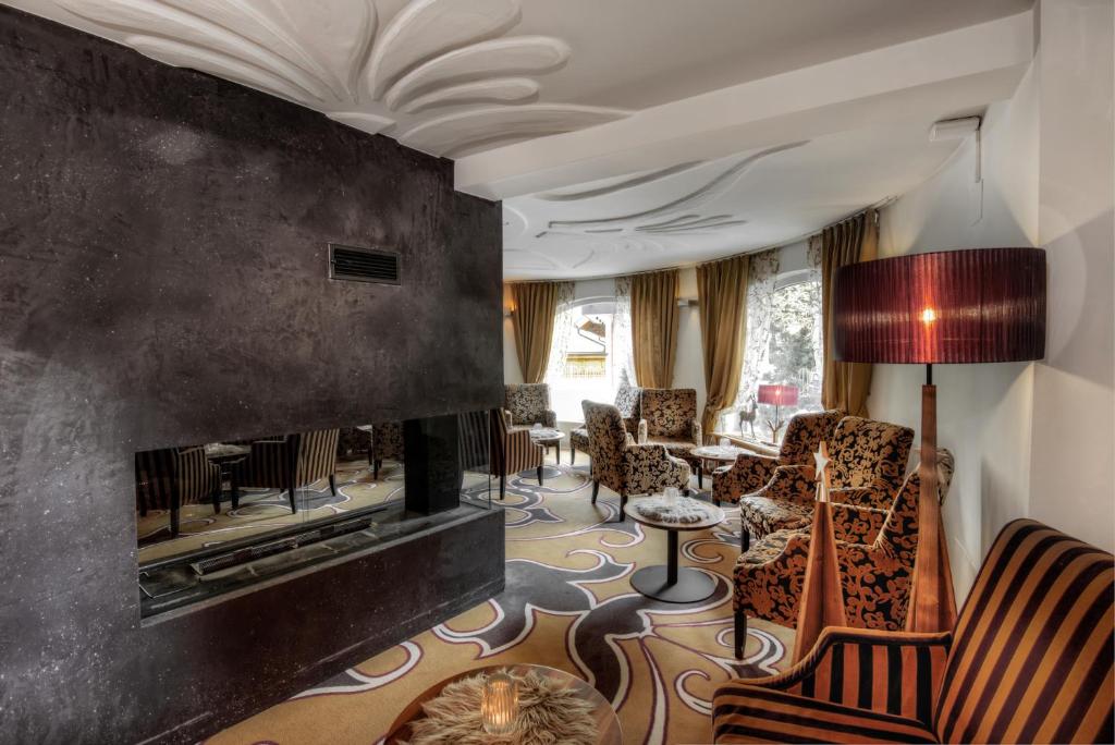 a living room with a fireplace and chairs at Hotel Brigitte in Ischgl