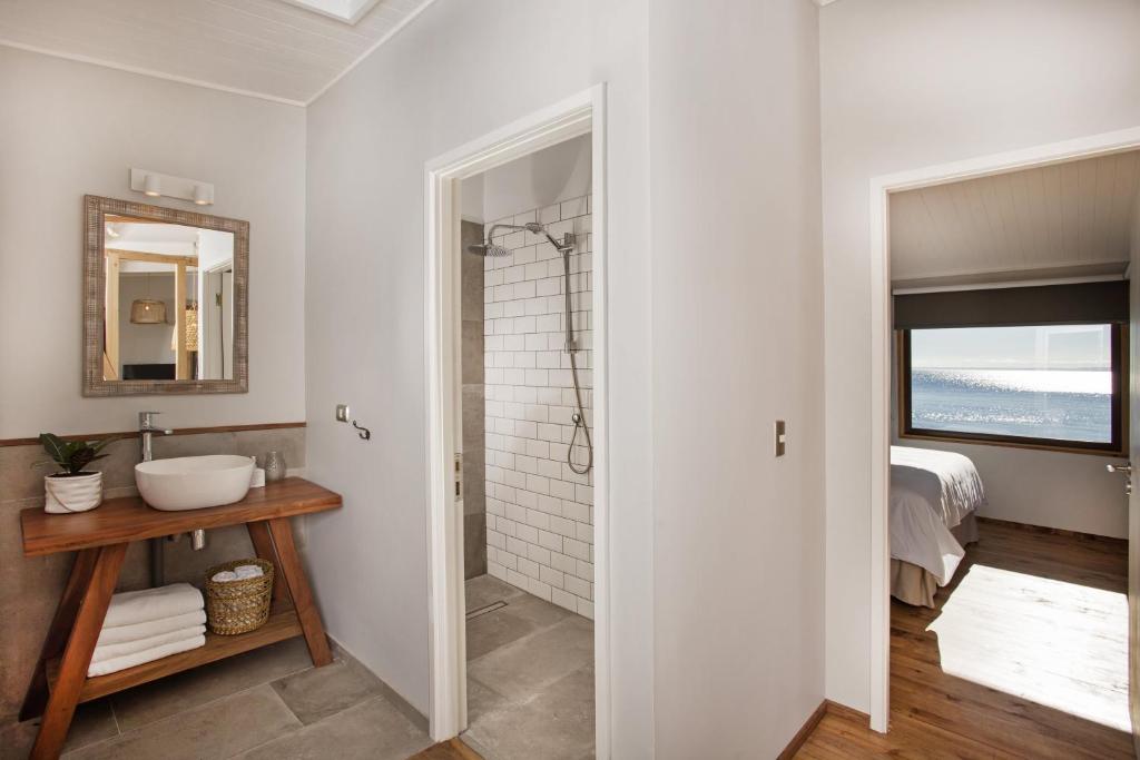bagno bianco con lavandino e doccia di Cala Melí a Puerto Varas
