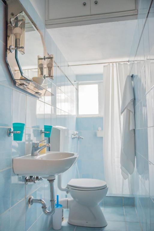 Łazienka z białą toaletą i umywalką w obiekcie ILIOCHARI sea view apartments Oropos - Kalamos w mieście Kalamos