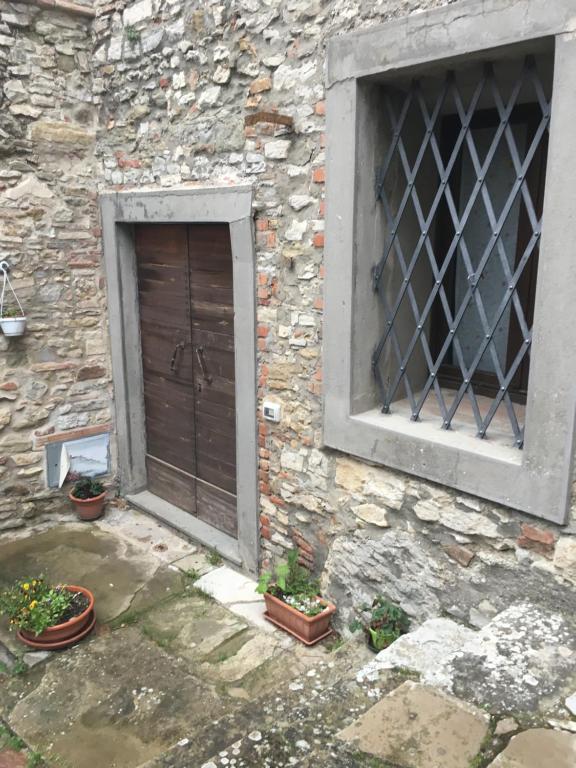 a building with a door and a window and potted plants at CASA AZZURRA MONTE SANTA MARIA TIBERINA in Monte Santa Maria Tiberina