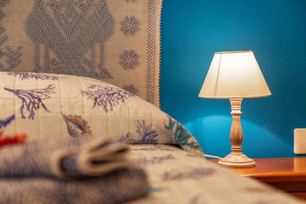una lampada seduta su un tavolo accanto a un letto di Casa vacanze Lungomare a Santa Maria Navarrese