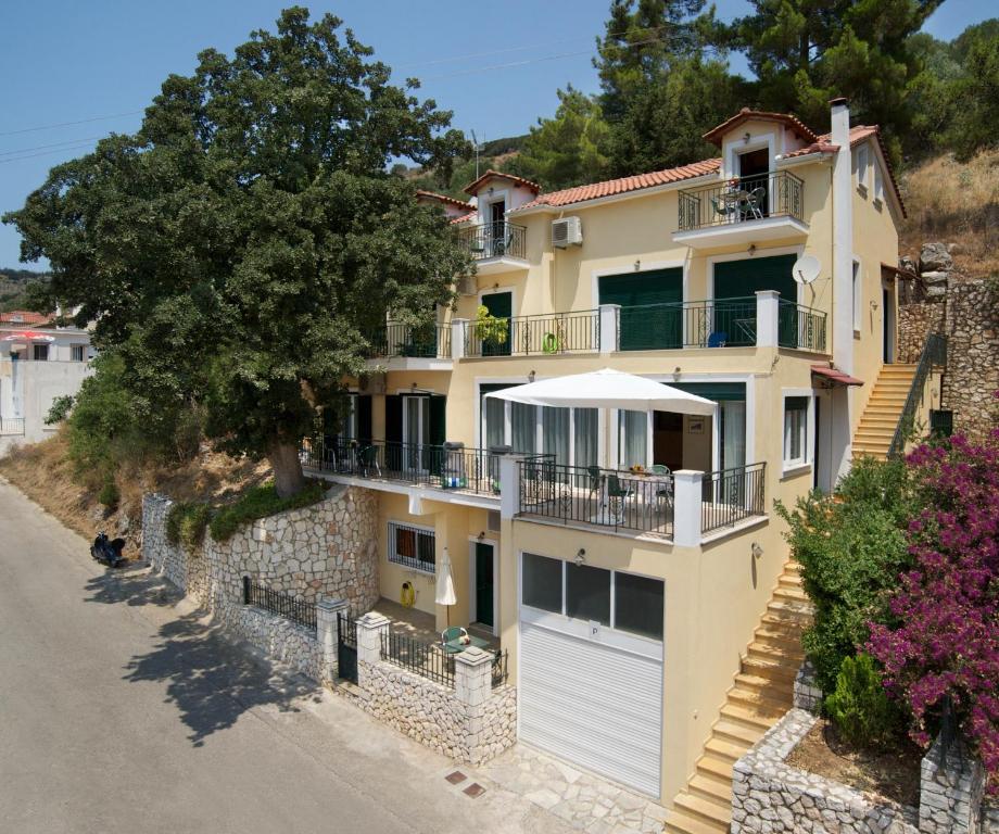 een groot huis met een witte garage bij Faos Luxury Apartments in Ayia Evfimia
