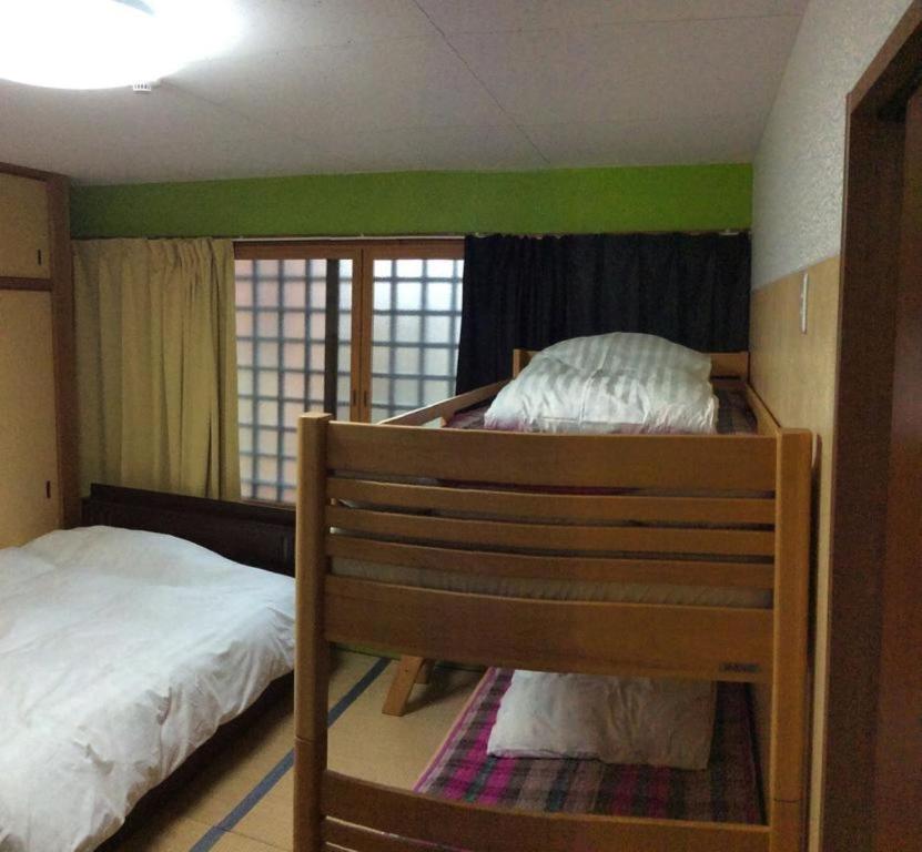 a bedroom with two bunk beds and a green wall at Gaisei Building 3F / Vacation STAY 4092 in Kyoto