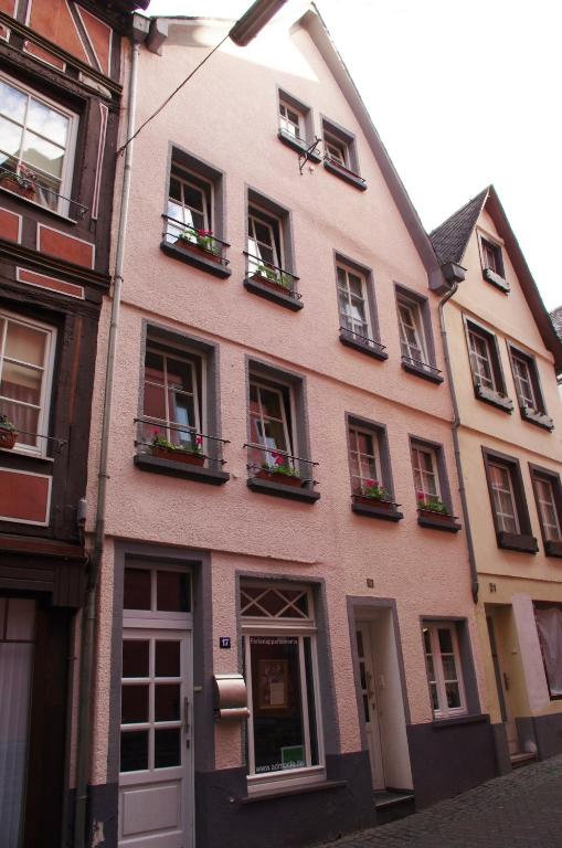 a pink building with windows and flower boxes at Ad Monte in Cochem