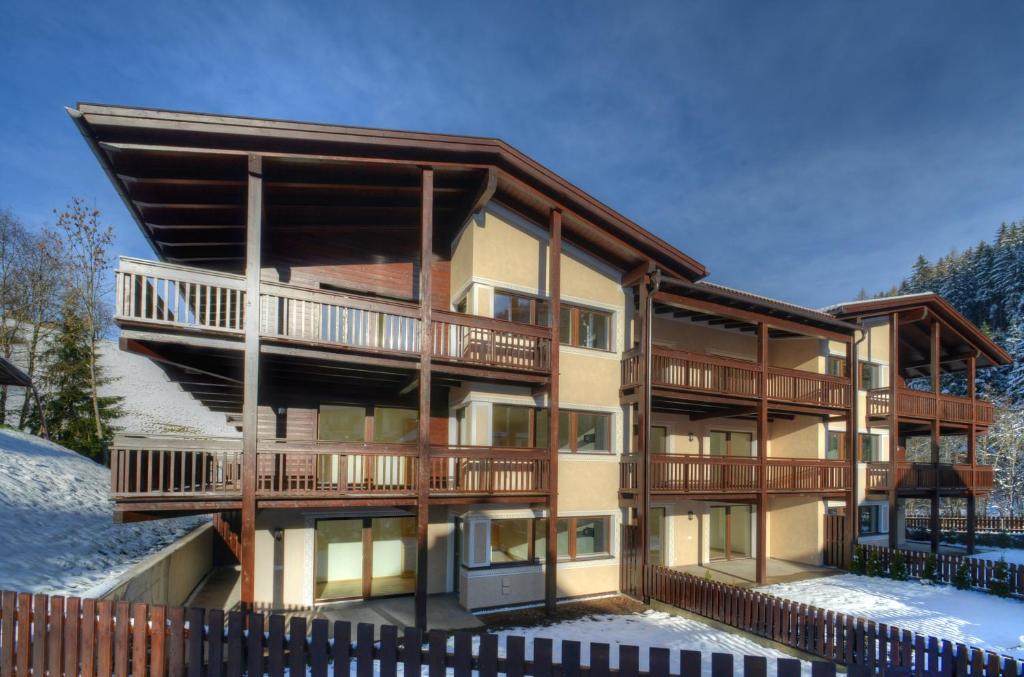 a large apartment building with a balcony in the snow at Chalet Martin in Valdaora