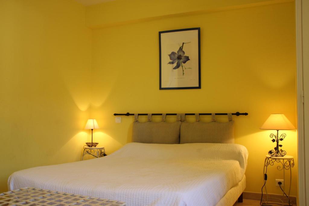 a bedroom with a large white bed and two lamps at Le Provençal in Aups