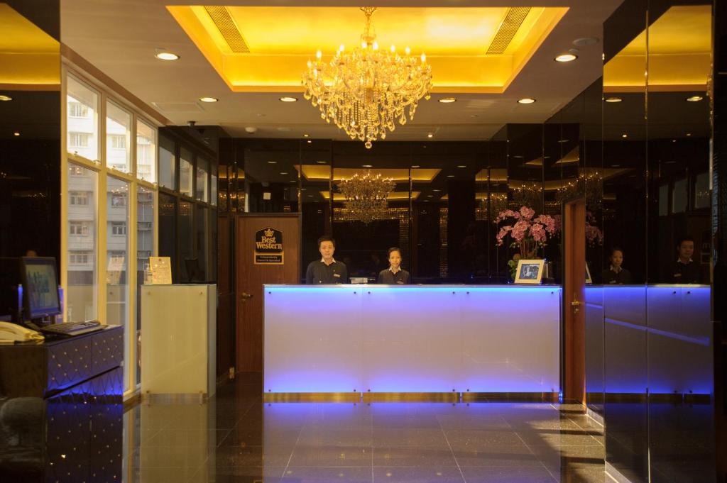 a lobby with two men standing at a reception desk at Best Western Hotel Causeway Bay in Hong Kong