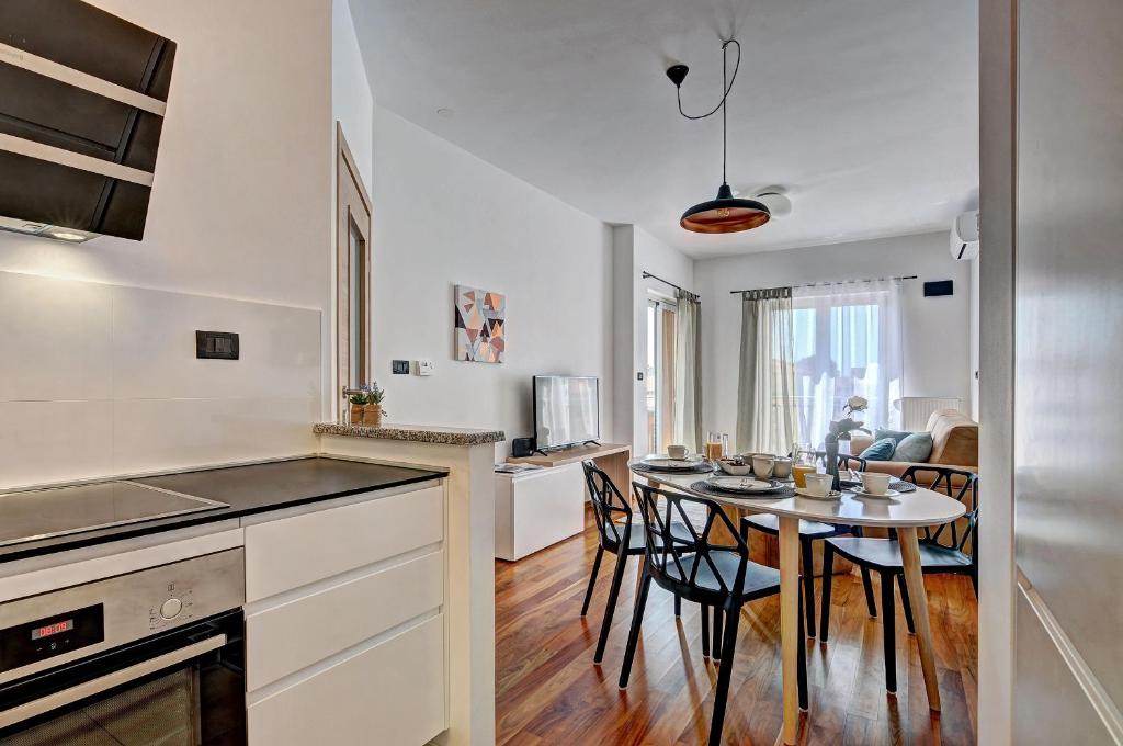 a kitchen and dining room with a table and chairs at PR Apartment Fazana in Fažana