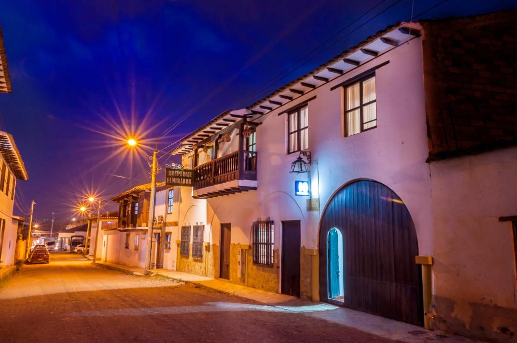 uma rua da cidade à noite com edifícios e luzes de rua em Hospedaje El Mirador em Villa de Leyva