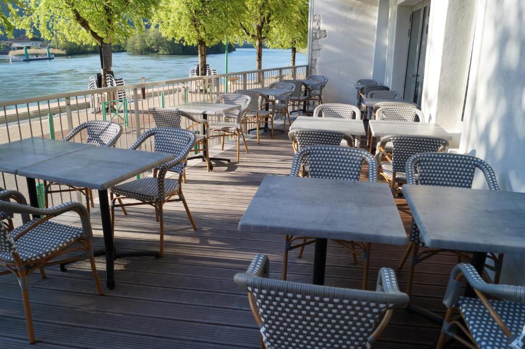 a row of tables and chairs on a deck at hotel du Rhône in Seyssel