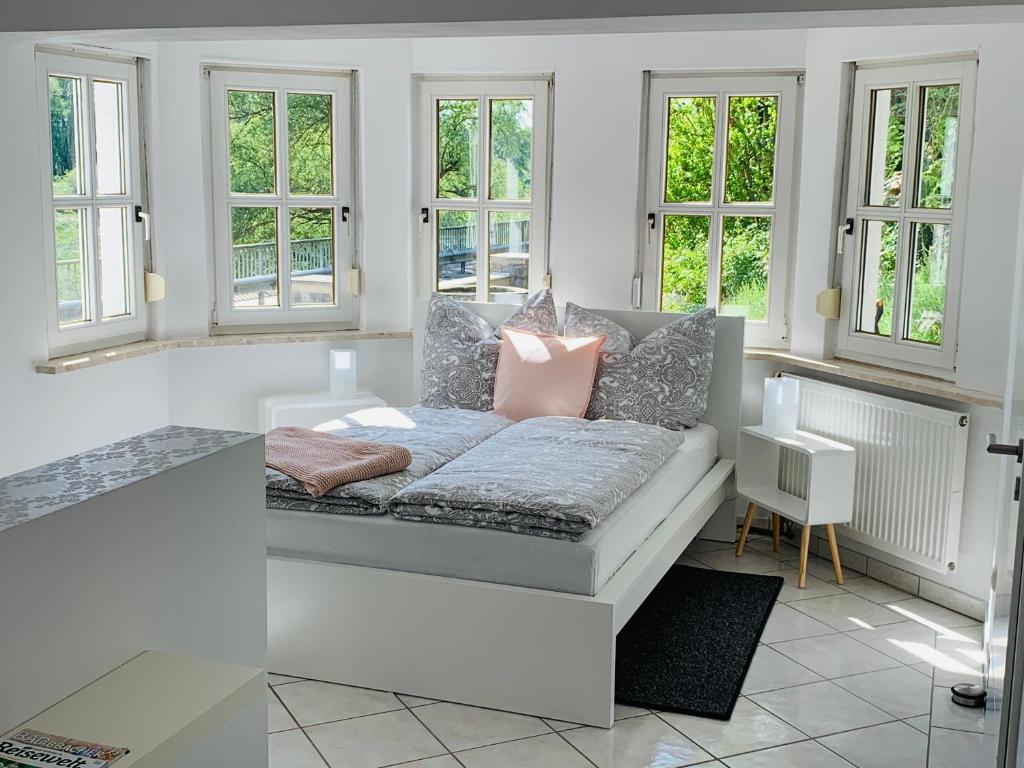 sala de estar blanca con sofá y ventanas en Apartment Donaublick en Bad Abbach