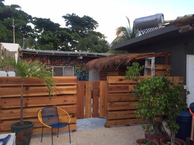 a wooden bench in front of a wooden fence at Wabi Hostel in Playa del Carmen