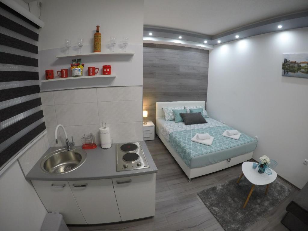 Kleines Zimmer mit einem Bett und einem Waschbecken in der Unterkunft Apartman DMD in Trebinje