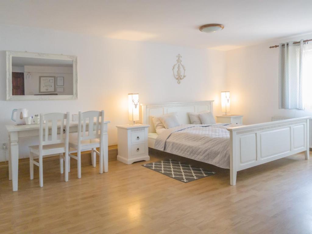 カルパチにあるVilla Retroのベッドルーム(白いベッド1台、テーブル、椅子付)